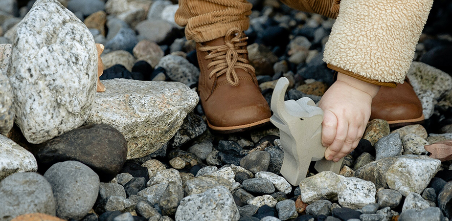 Child lifting elephant toy. Photo by Tatiana Syrikova