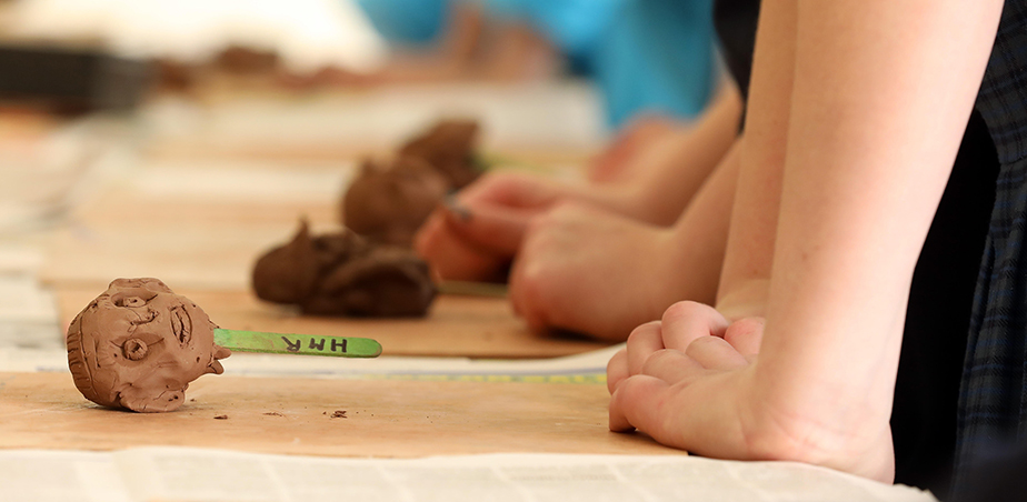 Highlanes Gallery Primary School Programme, Class Workshop, Spring 2022. children's hands pressing edge of table with clay heads on table