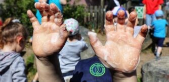 Childs hands covered in soap bubbles