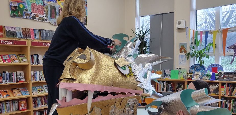 Students from Marino College decorate a giant golden fish made from colourful paper and card.