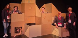 People stand amongst boxes on a stage for Baboro Festival Mentoring