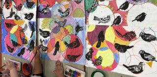 Students working on a colourful drawing, painting circles and printing birds