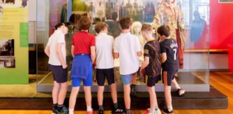 School tour gather around an exhibition at National Museum in Mayo