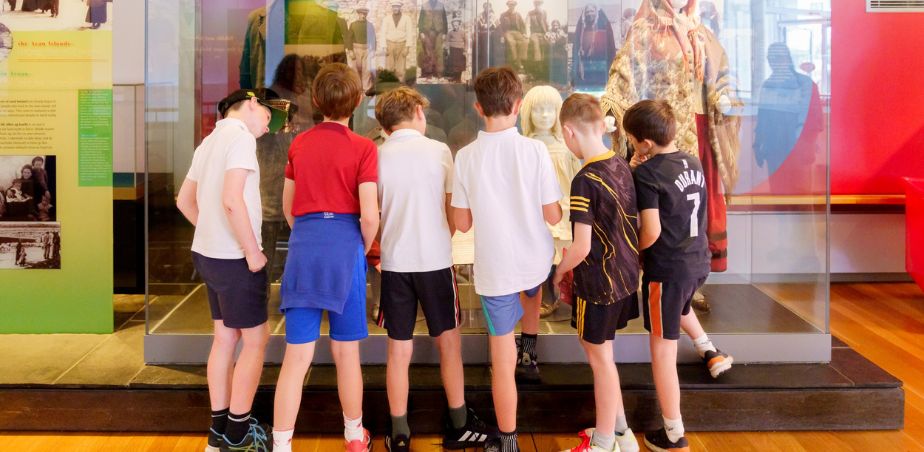 School tour gather around an exhibition at National Museum in Mayo