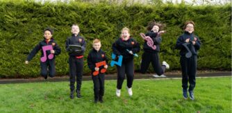 Primary school students jump with musical notes for Orpheus in the Garden
