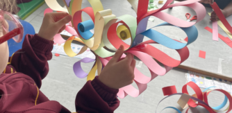 A students creates a creature with colourful strips of card