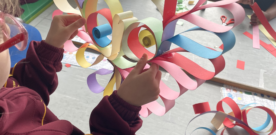 A students creates a creature with colourful strips of card