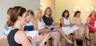 A group of teachers in discussion while sitting in an art gallery for Glucksman summer course 6-10 July