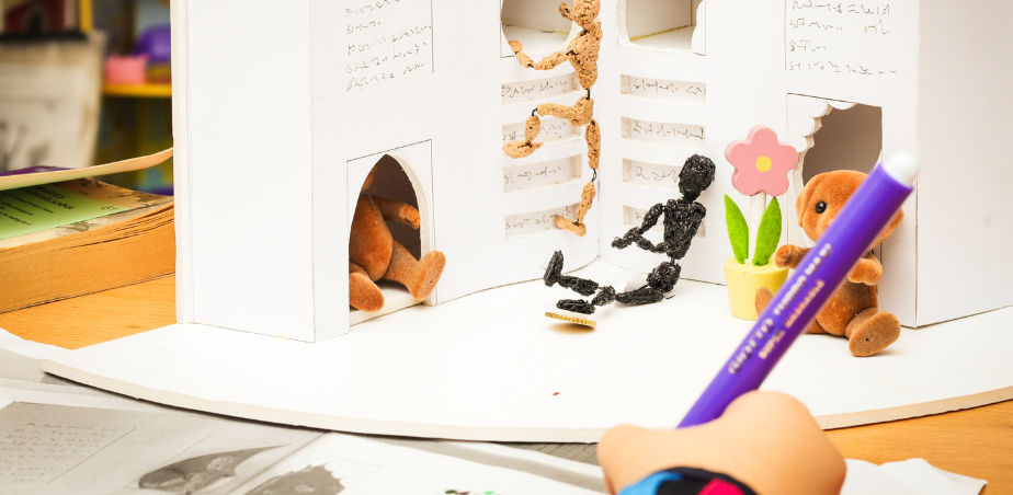 A child draws in front of a 3-D model of a Play space.
