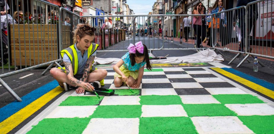 Kathi Burke, artist and children painting on the tarmac during the install of Open Road on Oliver Plunkett Street, Cork city. Photo credit: Clare Keogh